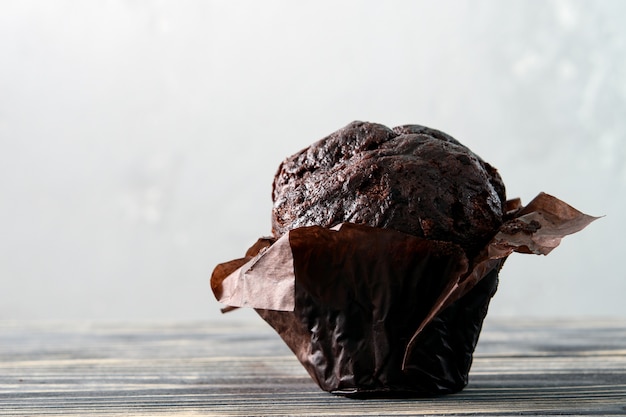 Muffin de chocolate o muffin sobre un fondo de madera gris.