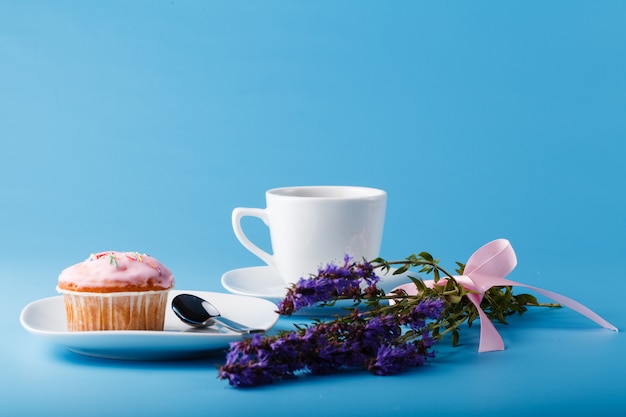 Muffin com glacê em um prato e uma caneca