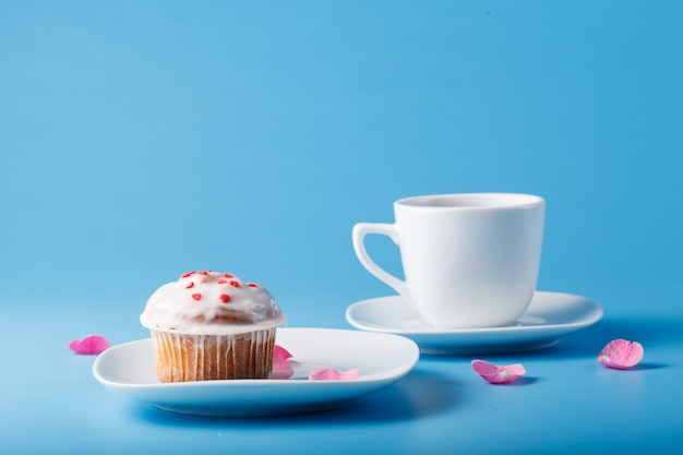 Muffin com glacê em um prato e uma caneca