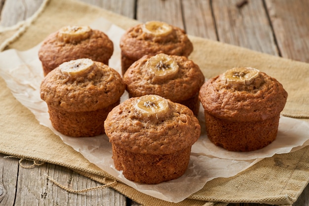 Muffin de banana, vista lateral. cupcakes no velho guardanapo de linho, mesa de madeira rústica, café da manhã com bolo