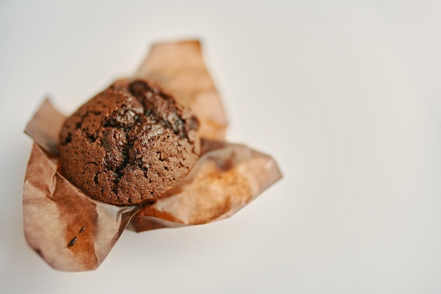 Muffin de chocolate close-up de bolinho de sobremesa deliciosa com chocolate amargo no espaço de cópia de papel de embrulho ...