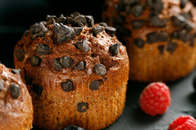 Muffin de chocolate com frutas Bolinhos apetitosos em um fundo escuro