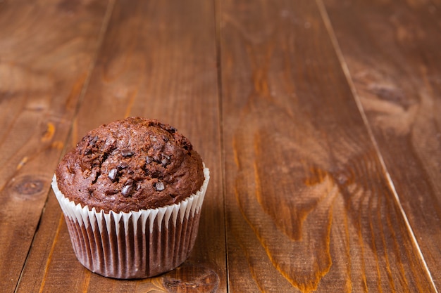 Muffin de chocolate na mesa de madeira escura