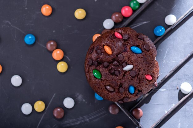 Muffin de chocolate polvilhado com bombons coloridos Bombons em glacê colorido