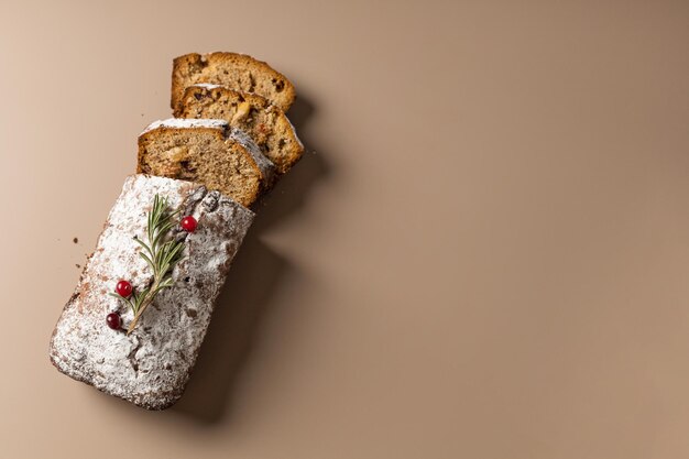 Muffin de Natal fatiado com frutas secas e nozes em um minimalismo de fundo bege