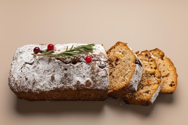 Muffin de Natal fatiado com frutas secas e nozes em um minimalismo de fundo bege