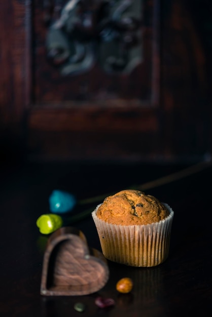 Muffin dourado no estilo romântico de foco seletivo de fundo escuro