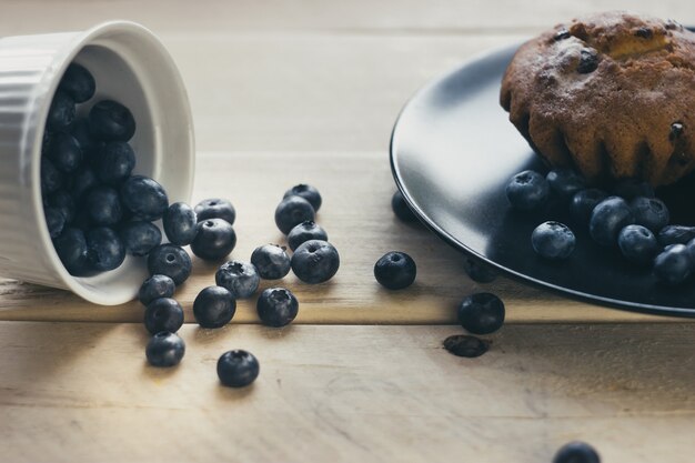 Muffin e mirtilos espalhados sobre a mesa