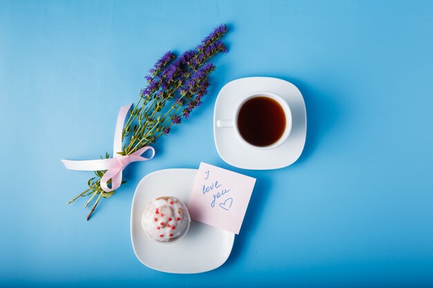 Muffin con glaseado en un plato y una taza