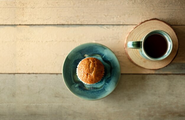 Muffin de plátano y café caliente en la mesa de madera. Estilo rústico