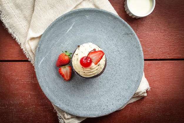 Muffin en un plato sobre una mesa de madera roja