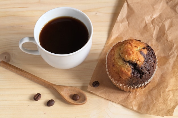 Muffin y taza de café en la mesa de madera