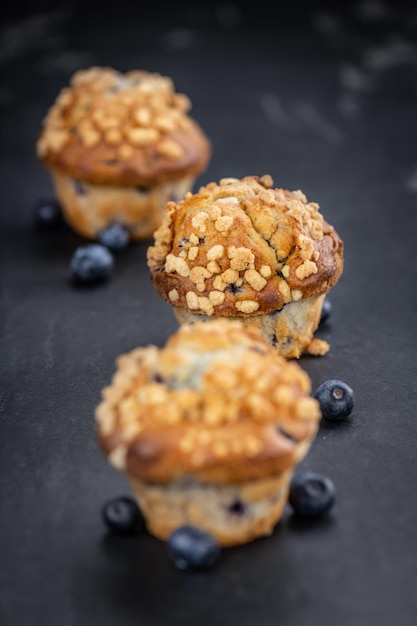 Muffins de arándanos recién hechos en una losa de pizarra primer plano enfoque selectivo