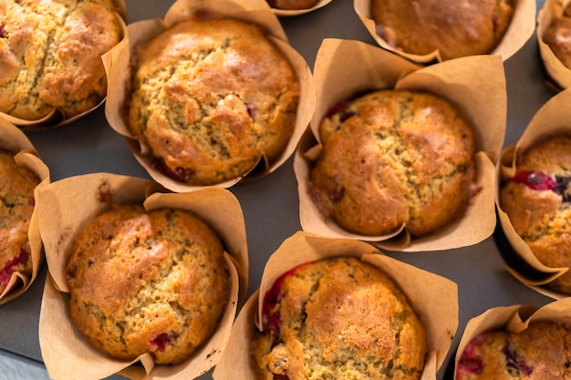 Muffins de arándanos recién horneados en moldes para muffins de papel marrón.