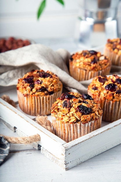 Foto muffins de avena caseros frescos con arándanos secos en bandeja de madera blanca postre sin gluten