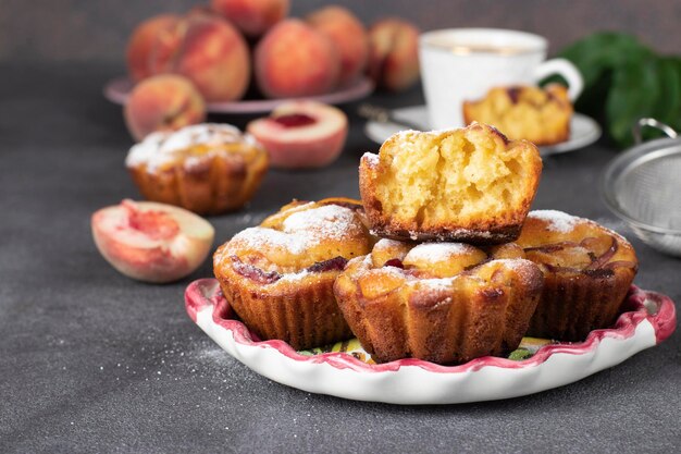 Muffins caseiros com pêssegos no prato fundo cinza