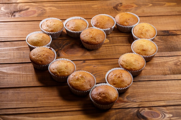 Muffins caseiros embrulhados em papel na placa de madeira