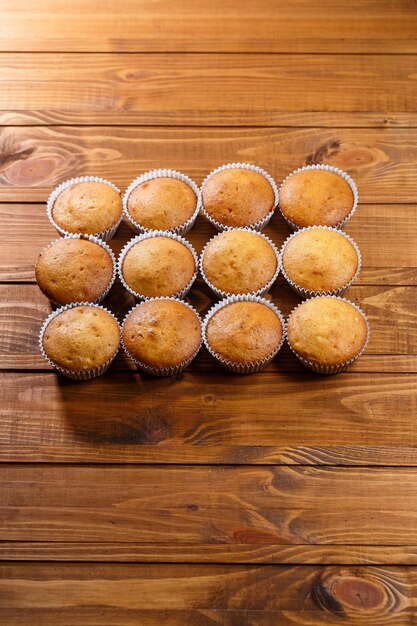 Muffins caseiros embrulhados em papel na placa de madeira