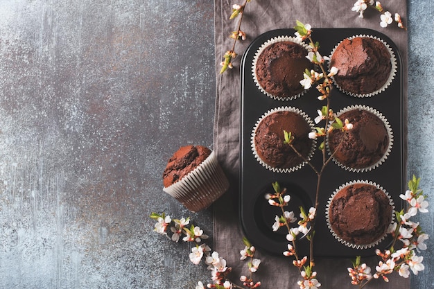 Muffins de chocolate y cacao planos con ramas de flores concepto del día de la madre o el padre