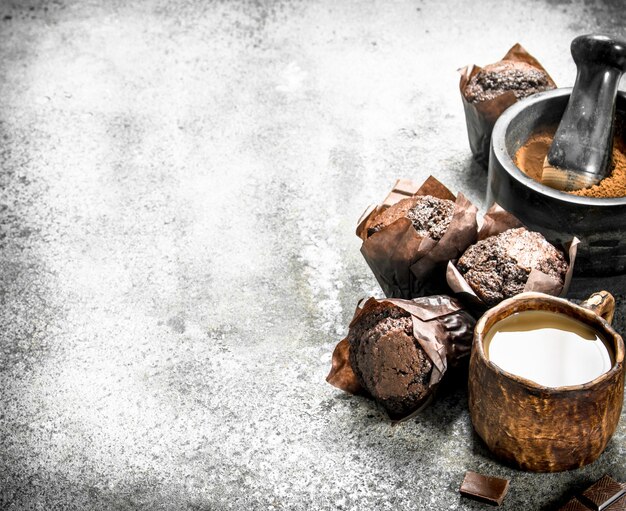 Muffins de chocolate con café y cacao en mesa rústica.