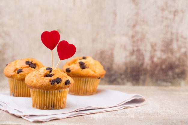 Muffins de chocolate caseros con corazón, fondo vintage.