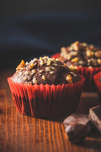 Muffins de chocolate caseros o cupcakes espolvoreados de nueces sobre una tabla de madera