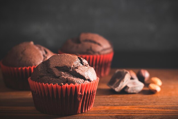 Muffins de chocolate caseros o pastelitos en una mesa de madera y fondo oscuro