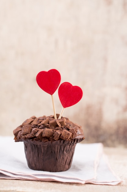 Foto muffins de chocolate con corazón sobre mesa de madera rústica