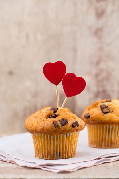 Muffins de chocolate con fondo vintage corazón, enfoque selectivo.