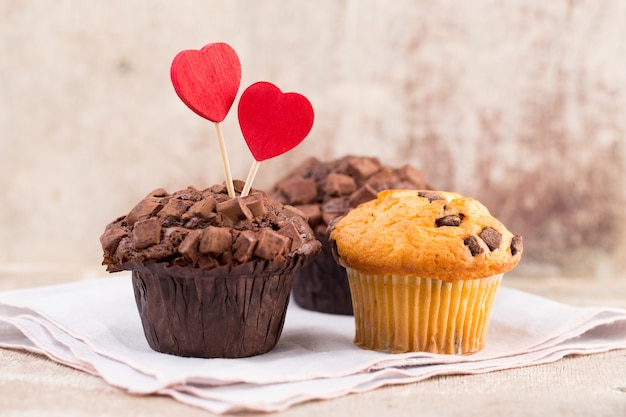 Muffins de chocolate con fondo vintage corazón, enfoque selectivo