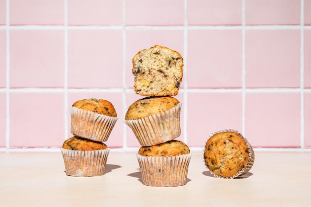 Muffins de chocolate y plátano en pila tiro sobre fondo colorido luz dura horizontal