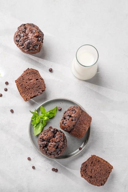 Muffins de chocolate en un plato con menta en un fondo claro con leche El concepto de saludable hecho en casa horneado para el desayuno