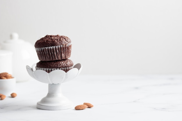 Muffins de chocolate en un puesto de pastel blanco sobre una mesa blanca