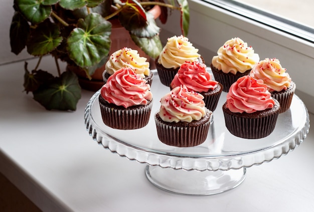 Foto muffins de chocolate con sombrero de crema rosa y blanca