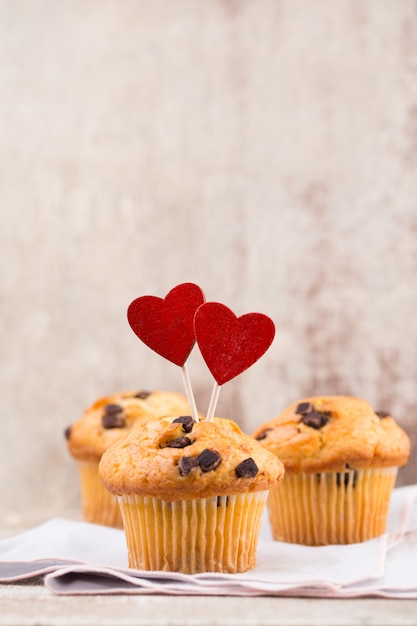 Muffins de chocolate con superficie vintage de corazón, enfoque selectivo.