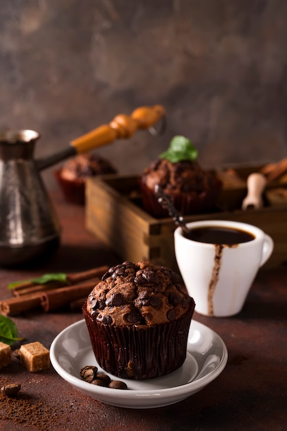 Muffins de chocolate con una taza de café en la mesa