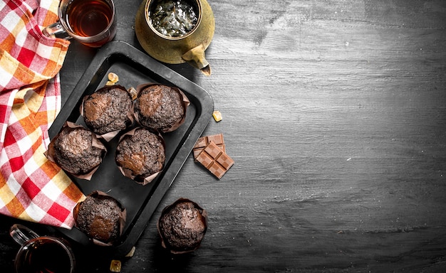 Muffins de chocolate con té fresco. En la pizarra negra.