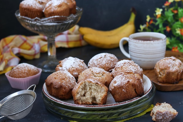 Muffins com bananas estão localizados em placas contra um fundo escuro