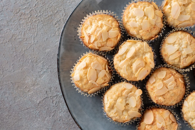 Muffins com queijo cottage decorado com flocos de amêndoa num prato azul.