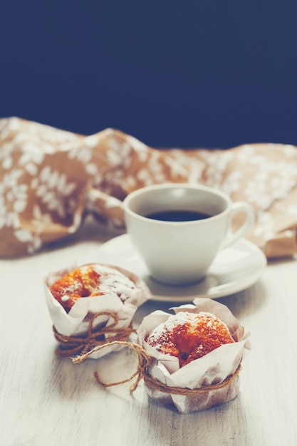 Muffins cozidos frescos doces com xícara de café