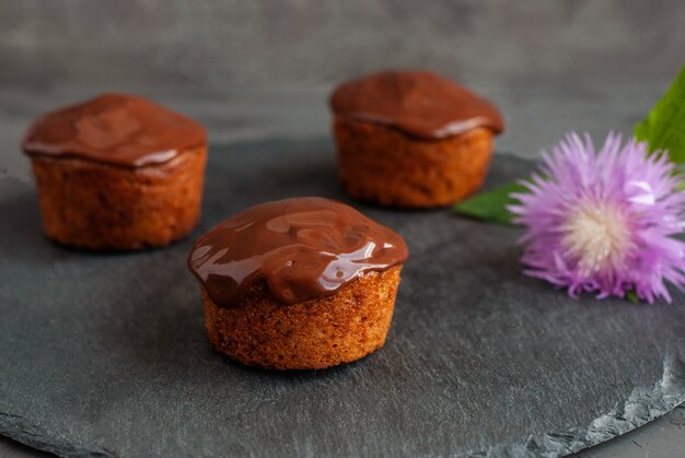 Muffins de abóbora despeje ganache de chocolate, decore com bolos coloridos