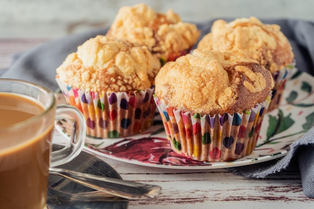 Muffins de baunilha de mirtilo caseiros recém-assados em um prato acompanhados de um café com leite. Vista aérea, vista alta. Comida natural de conceito, comida caseira.