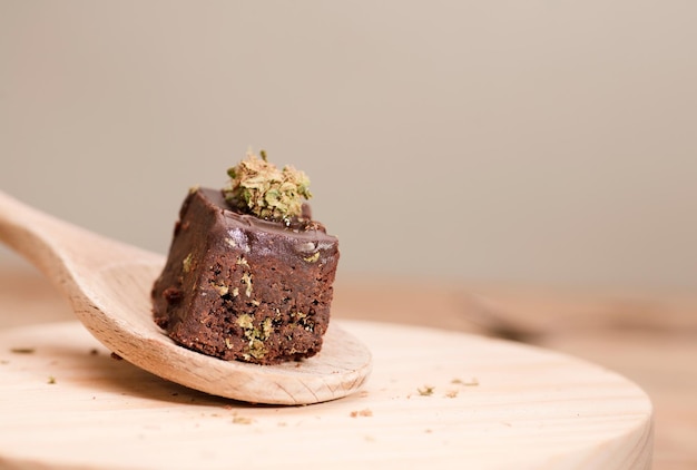 Muffins de chocolate com botões de cannabis na colher de pau Bolo de maconha em uma mesa de madeira marrom