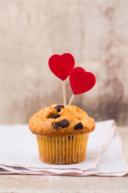 Muffins de chocolate com coração vintage, foco seletivo.