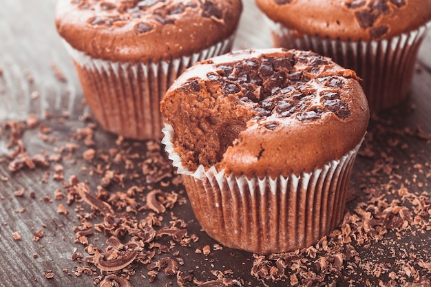 Muffins de chocolate com gotas de chocolate no fundo de madeira closeup