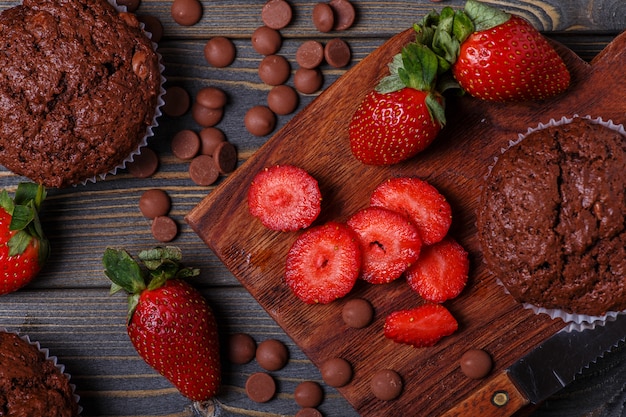 Muffins de chocolate com morango no escuro.