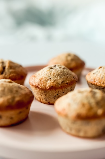 Muffins de chocolate e banana em um prato redondo rosa, close-up, foco seletivo