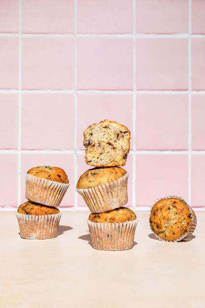 Muffins de chocolate e banana na pilha, filmados em fundo colorido, luz dura vertical