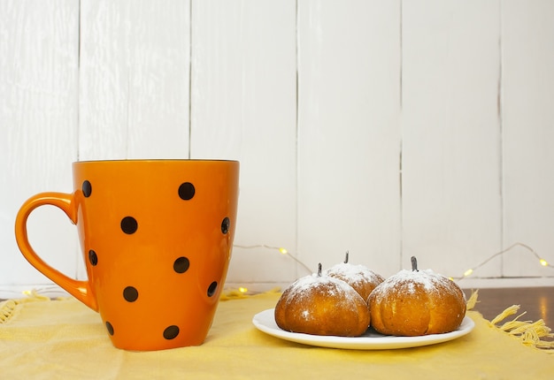 Muffins de chocolate em formato de abóbora na mesa ao lado da xícara