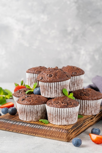 Muffins de chocolate ou cupcakes com gotas de chocolate com frutas frescas e hortelã Copiar espaço